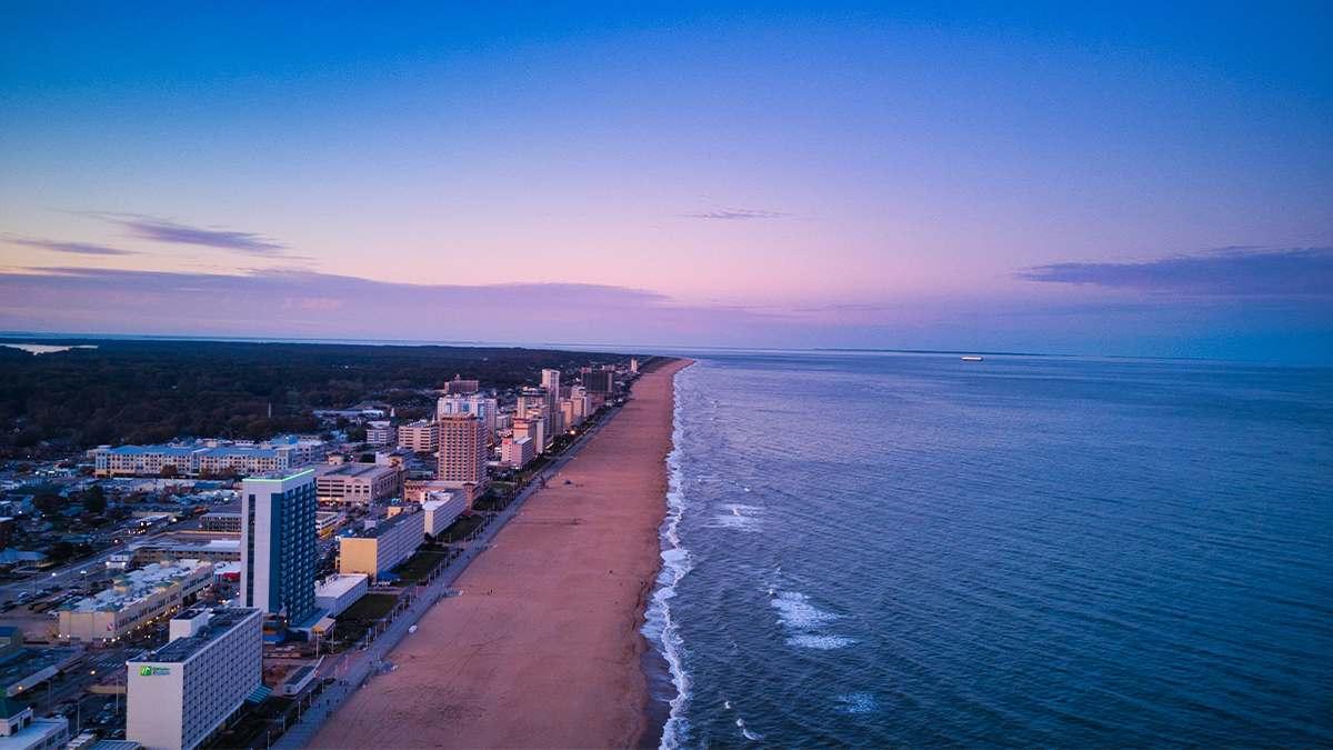 Aerial view looking over Virginia Beach with a purple sunset and no one on the beach in Virginia Beach, Virginia, USA