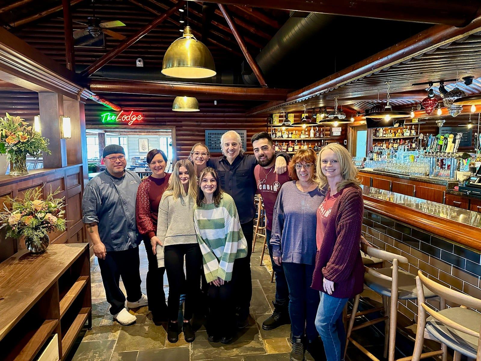 Co-owner Peter Poulos, center in black, stands with employees of Karl