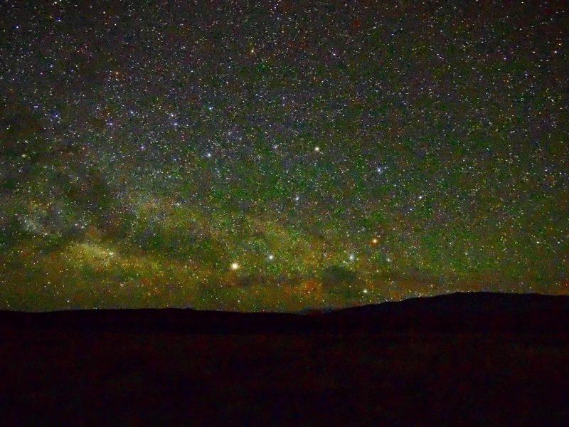 Two very bright stars, Alpha and Beta Centauri, with Crux, close to horizon in densely starry sky.