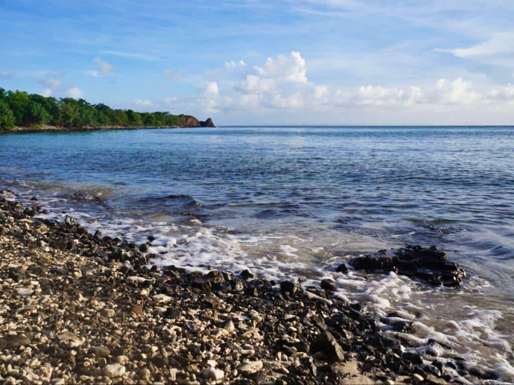 View of the calm water from the rocky shoreline of Melones Beach in Playa Sardinas I