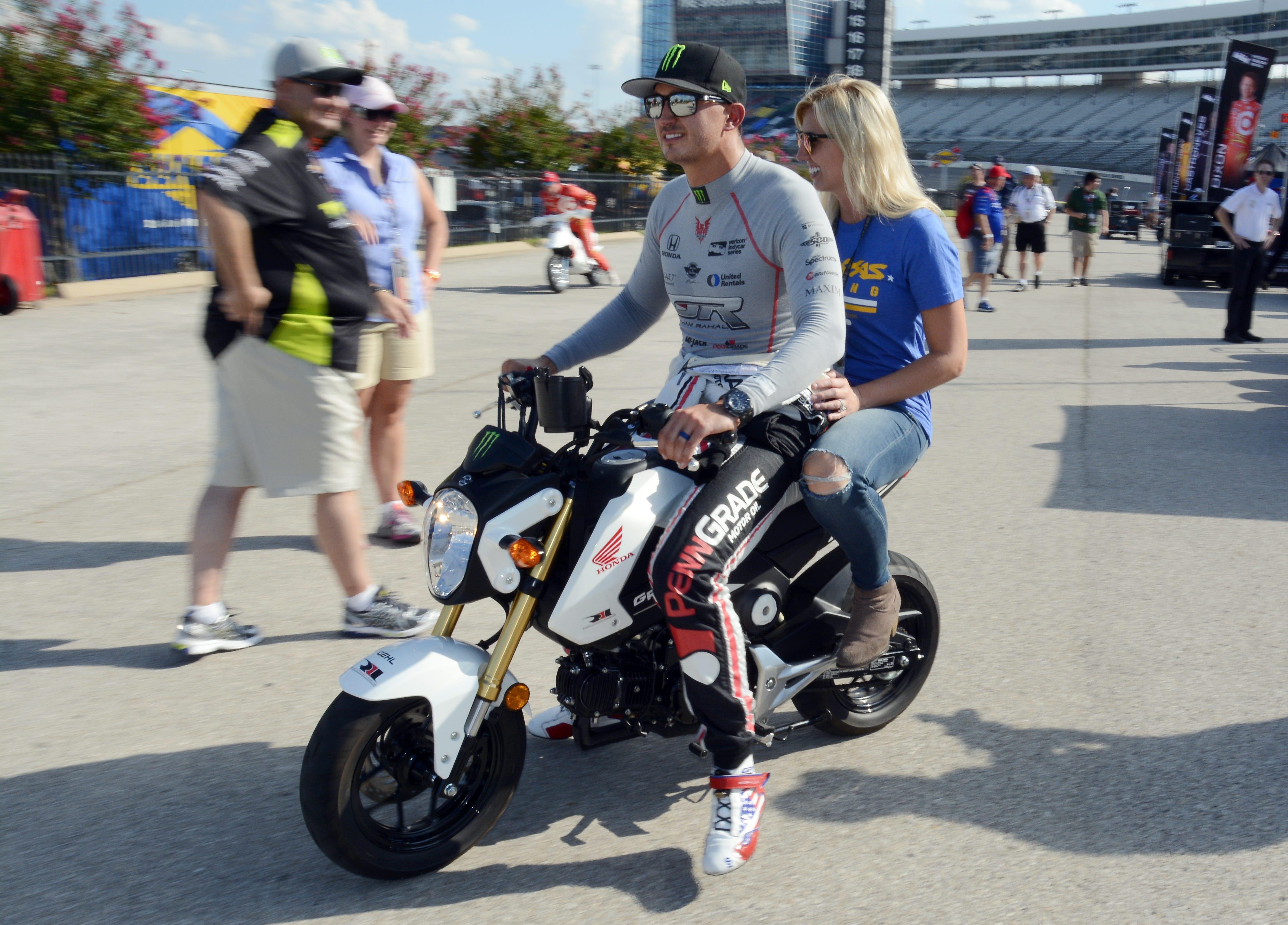 Graham Rahal and his wife, Courtney Force, ride a scooter on pit road in Augusta 2016 at Texas Motor Speedway in Fort Worth, Texas. Force will race May 18-20 in Topeka at the Menards NHRA Nationals at Heartland Motorsports Park, and Rahal is preparing for the Indianapolis 500 on May 27. [File photograph/The Associated Press]
