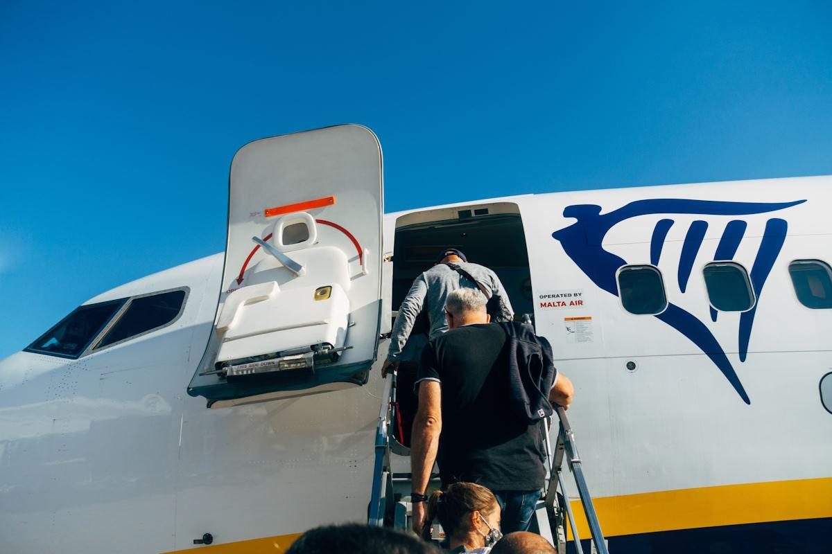 People climbing stairs to board a Ryanair plane