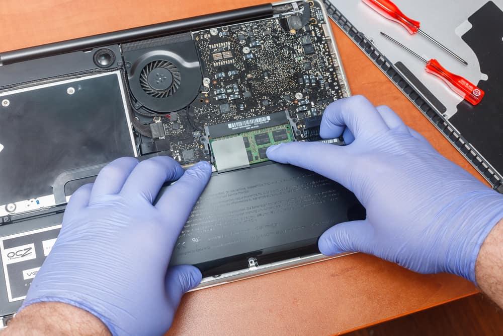 Service engineer replaces new battery in to the Apple macbook laptop