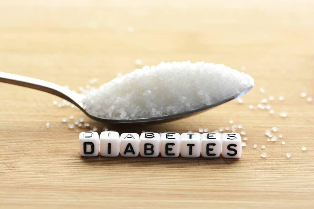 Diabetes block letters in crossword and sugar pile on a spoon