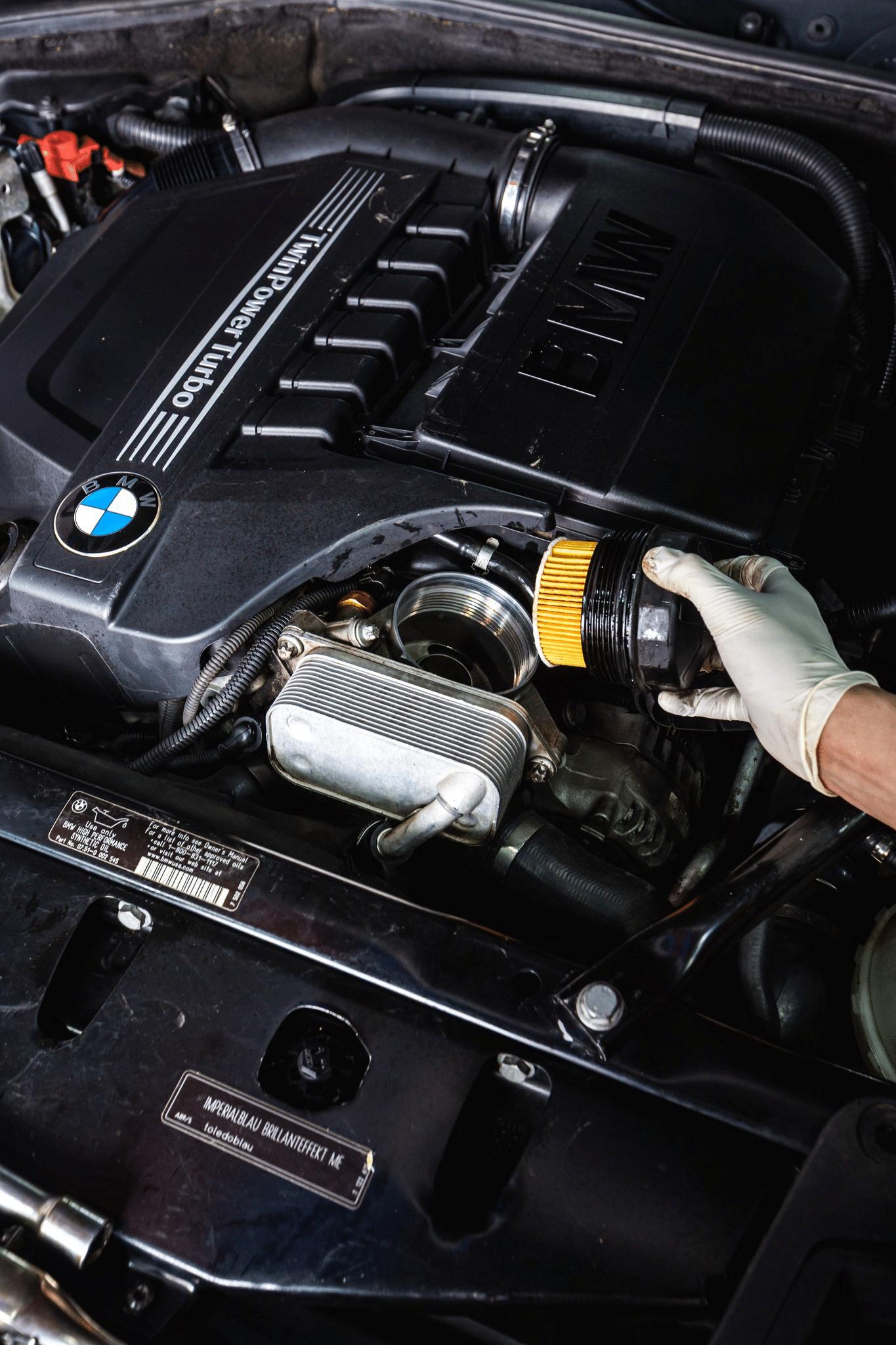 A mechanic replacing a car engine oil filter