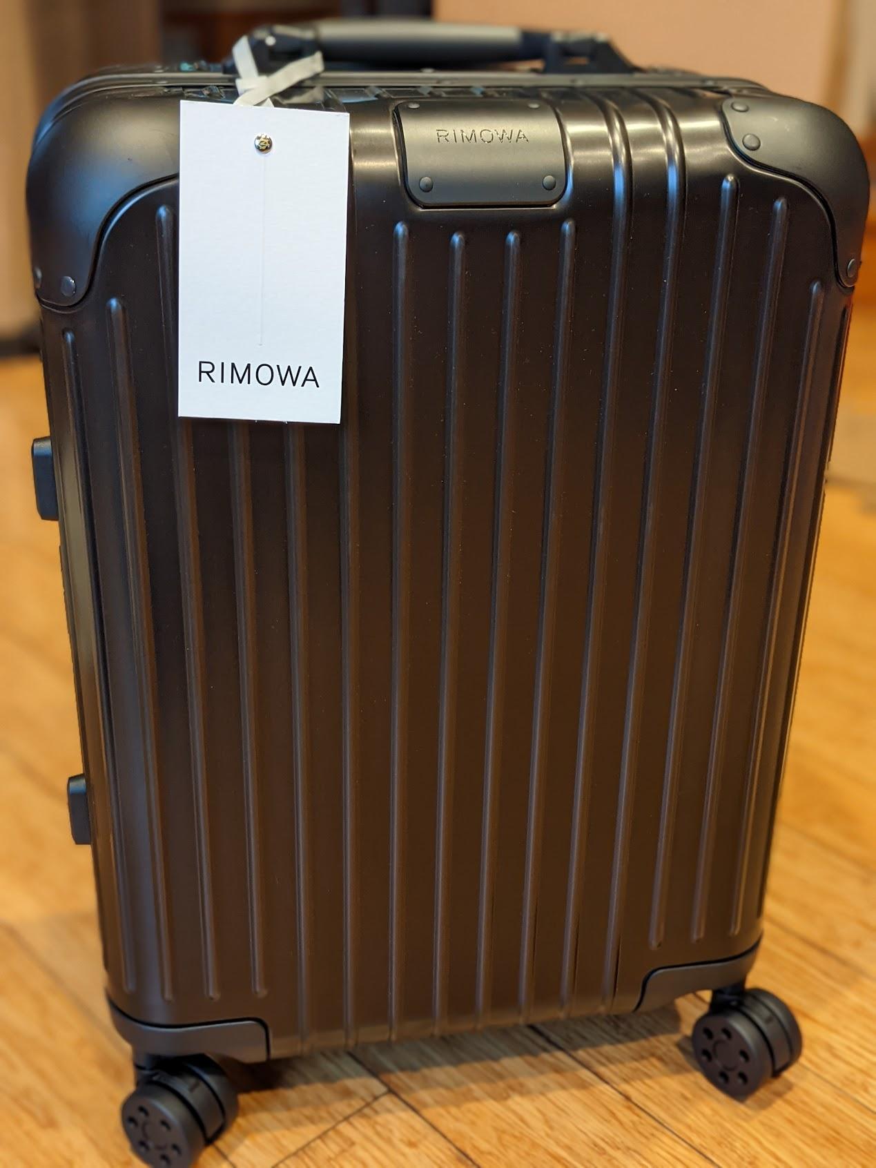 a black suitcase with a white tag on it