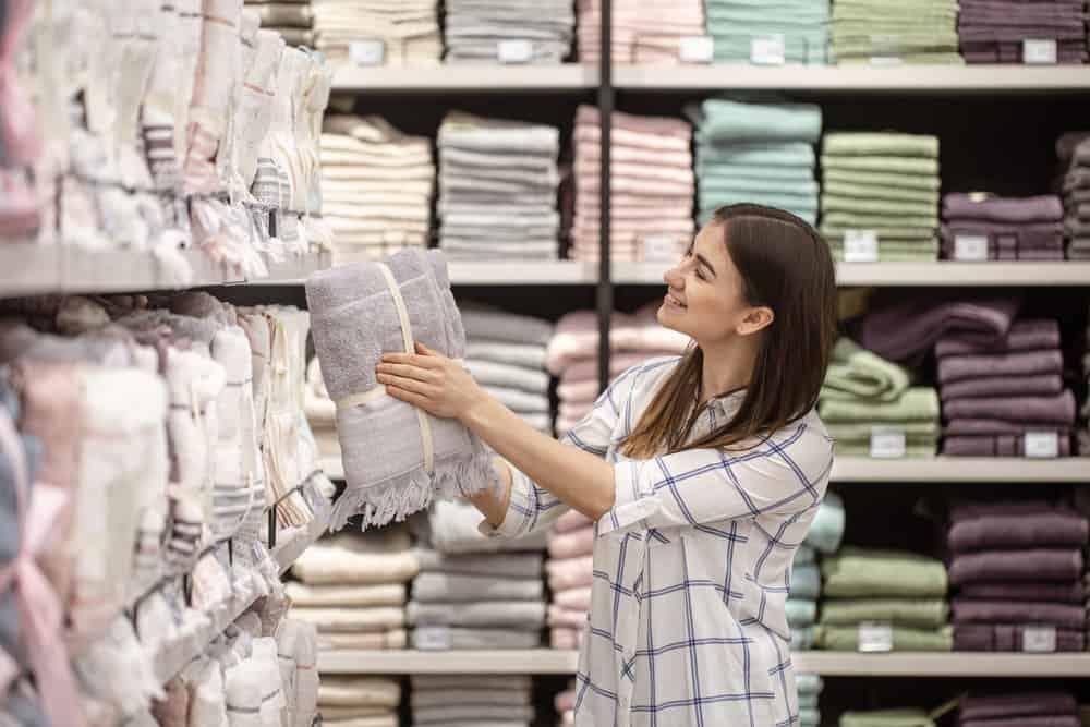 A young woman in a store chooses textiles. The concept of shopping for a home.