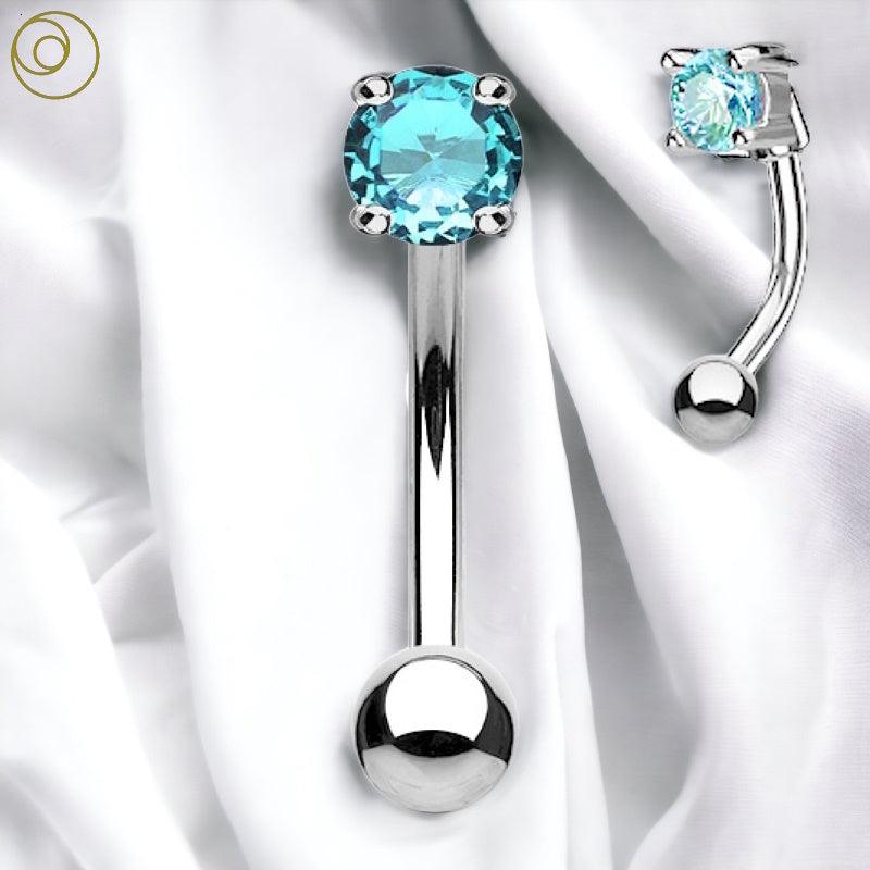 An aqua cubic zirconia eyebrow ring with a surgical steel curved barbell.