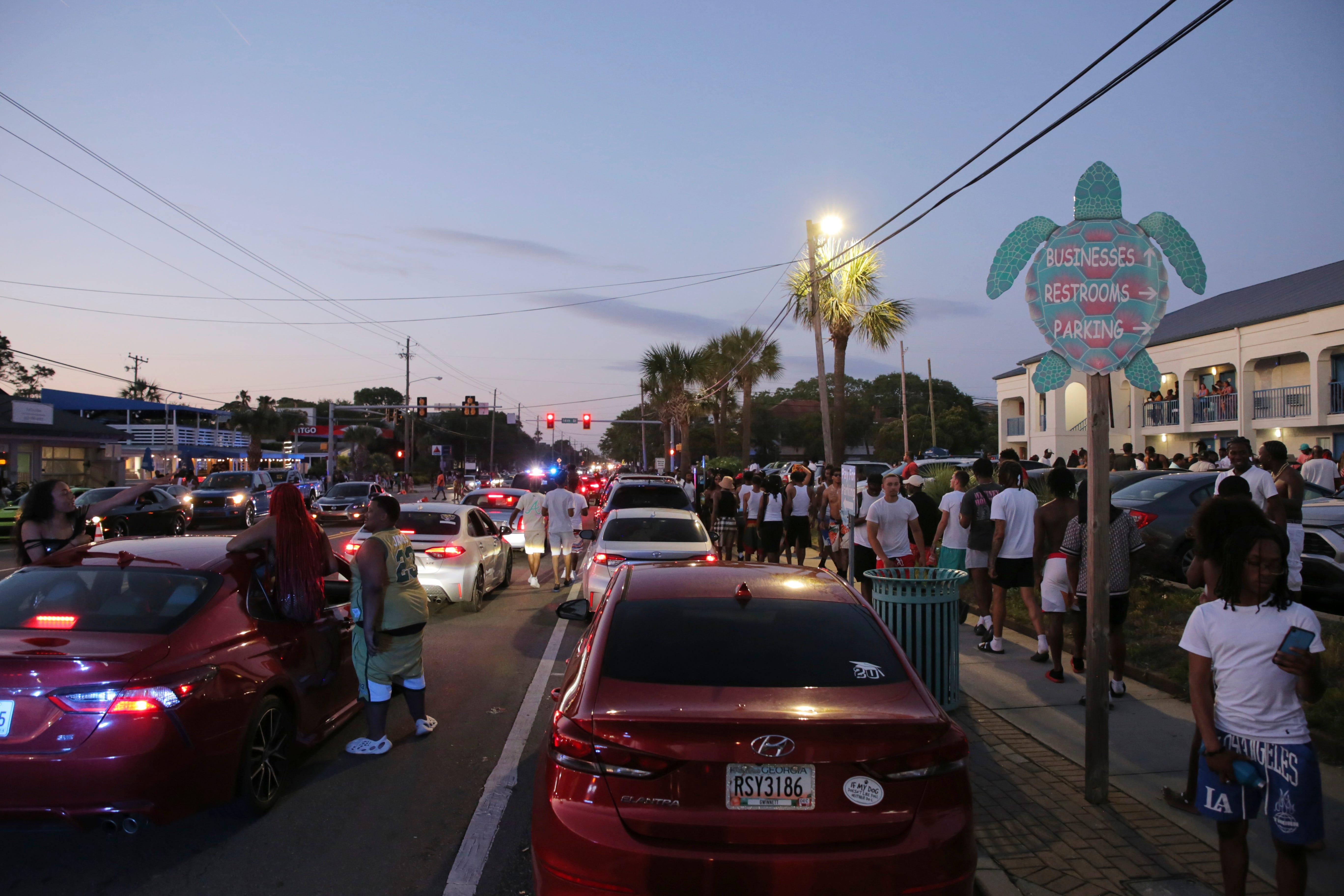 Party-goers hang out in the street during stand-still traffic caused by a past Orange Crush.