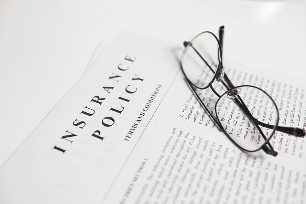 Owners title insurance policy with spectacles placed above them mentioning the terms and conditions